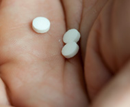 Hand holding round white pills