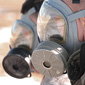 Two servicemembers wearing gas masks