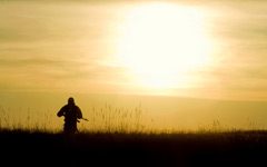  Silhouette of a soldier in front of the bright sun