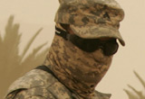 Soldier in goggles and camouflage fabric face covering in the desert
