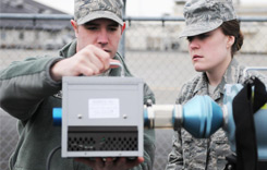 Two airmen with a radiation detection instrument